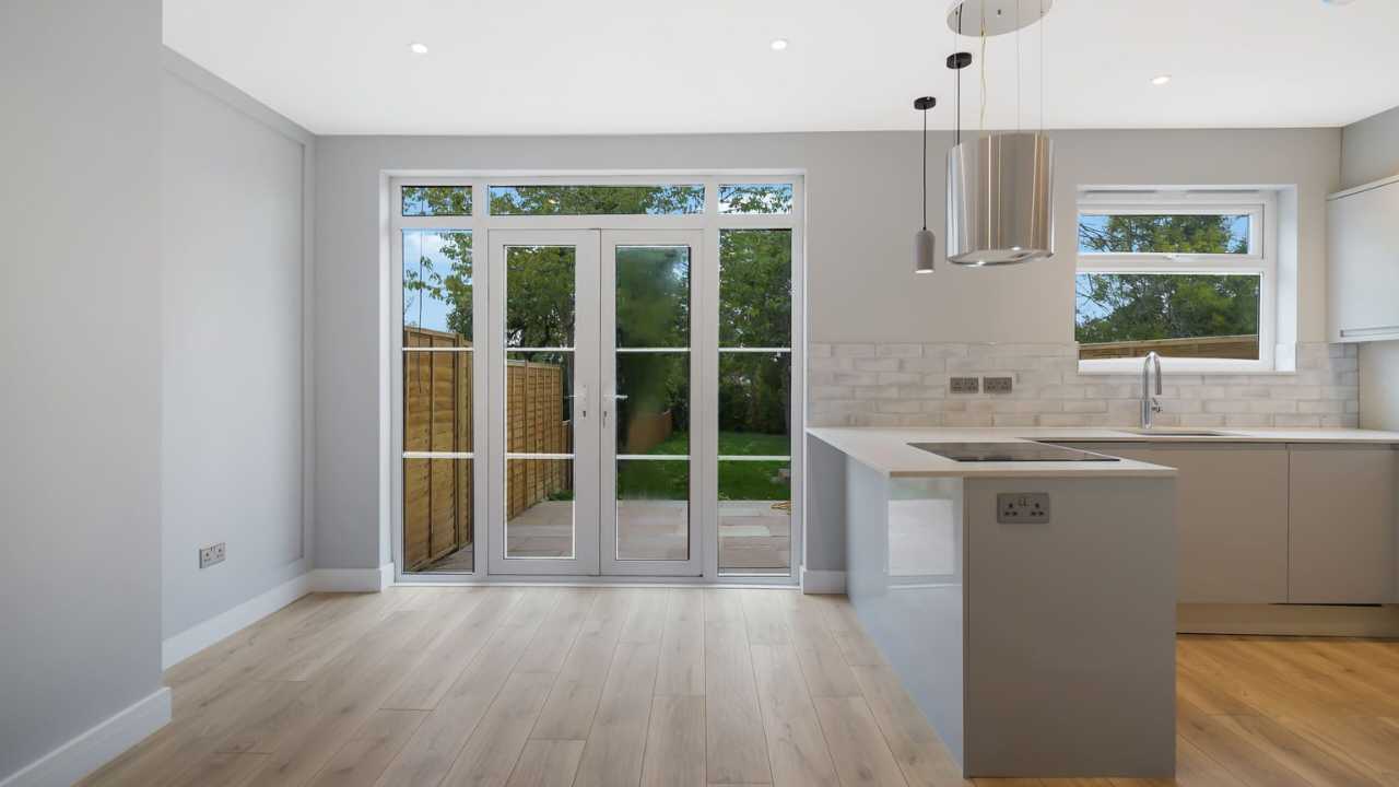 Modern open plan kitchen diner with bi fold doors leading to garden in Harrow property by Empire Chase.