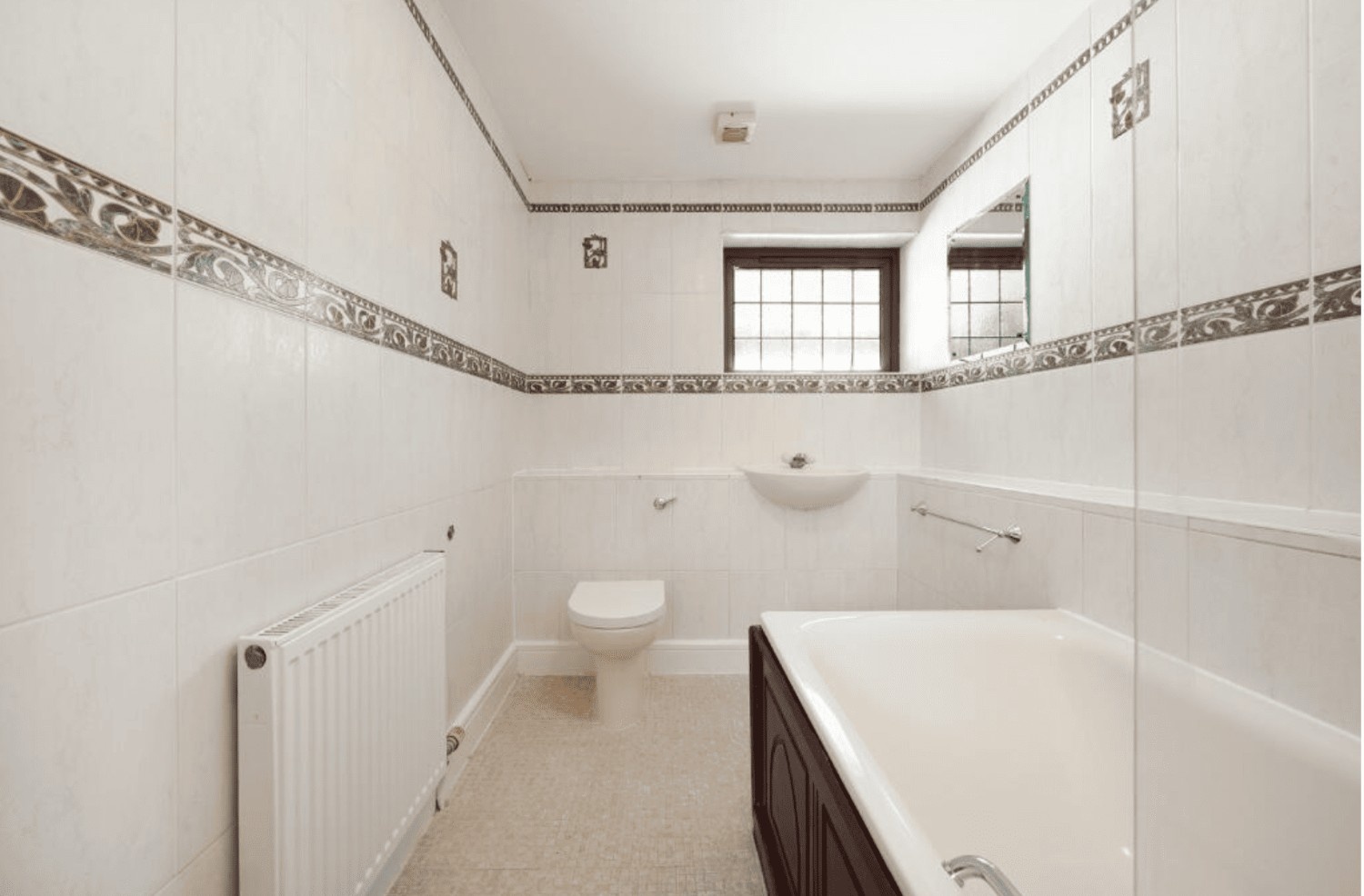 Family bathroom with bathtub, tiled walls and window in Cheney Street HA5 detached property.