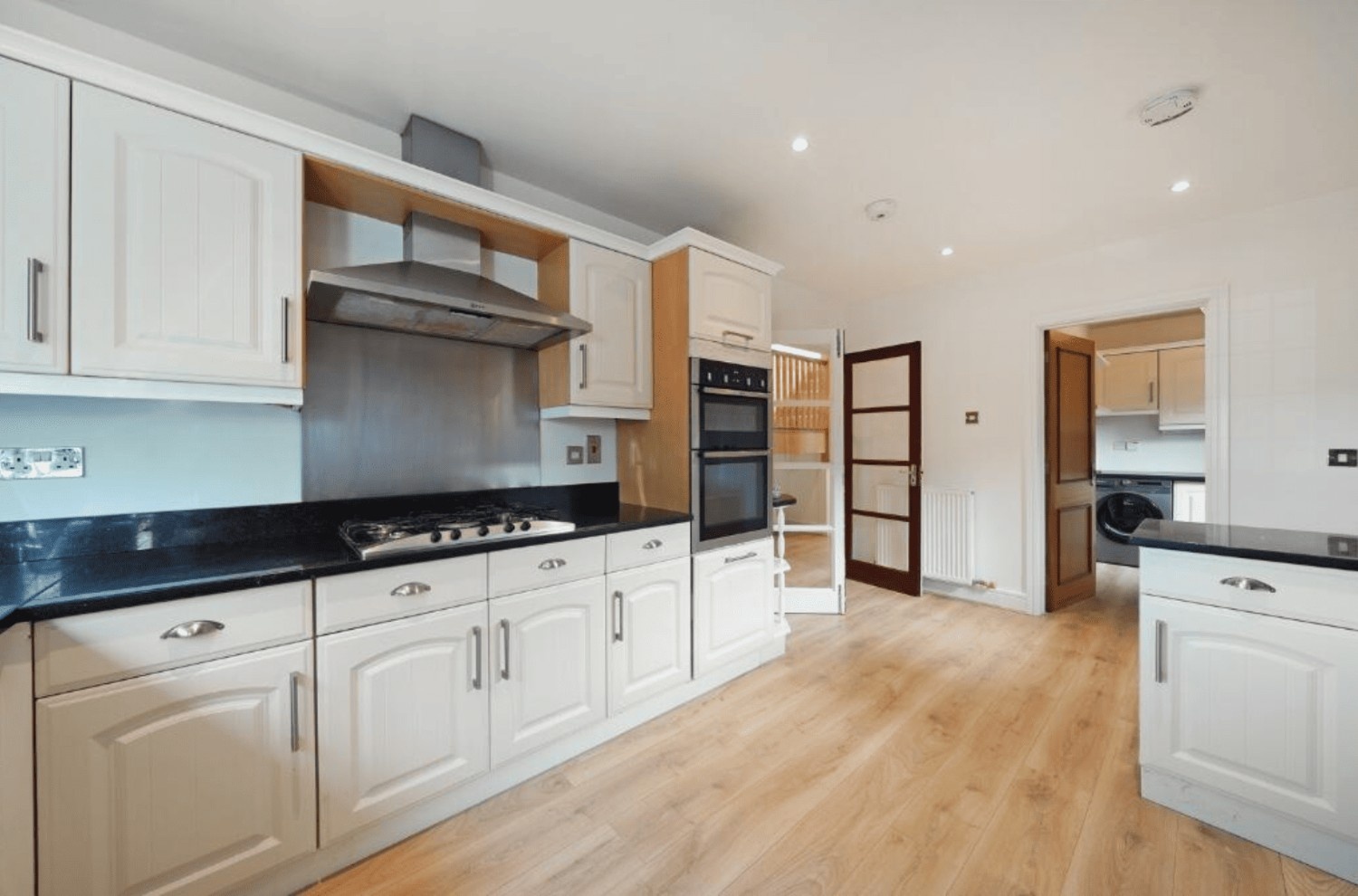 Contemporary fitted kitchen with black worktops and integrated oven in Cheney Street HA5 house for sale.
