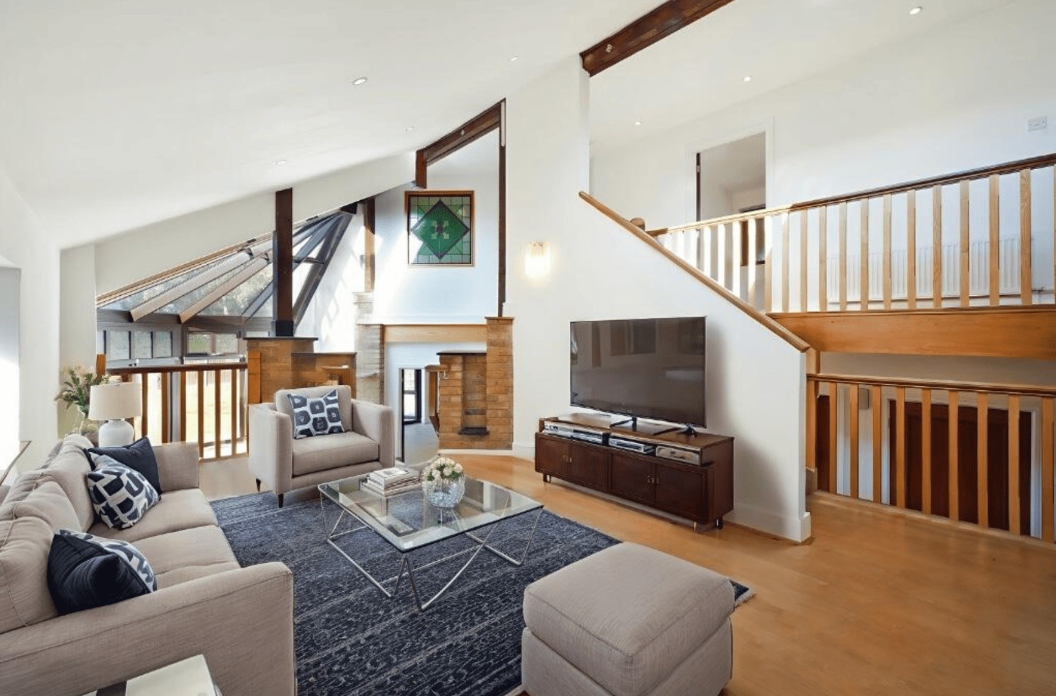 Spacious open plan living area with staircase, skylights and wood flooring in Cheney Street HA5 house