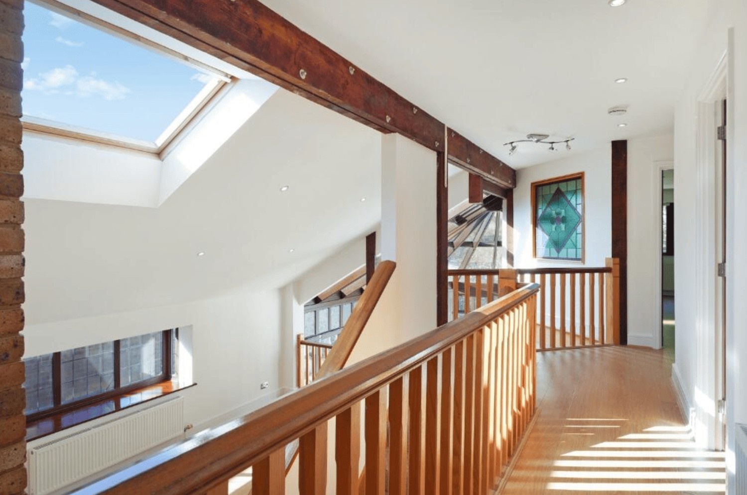First floor landing with wooden balustrade and skylight in Cheney Street HA5 detached house.
